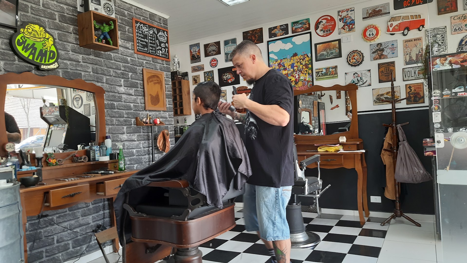 Barbeiro cortando o cabelo de um cliente dentro da Barbearia El Cabron's, no Bacacheri